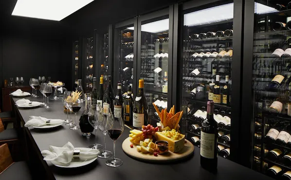 Wine vault with table set with red wine and cheese board