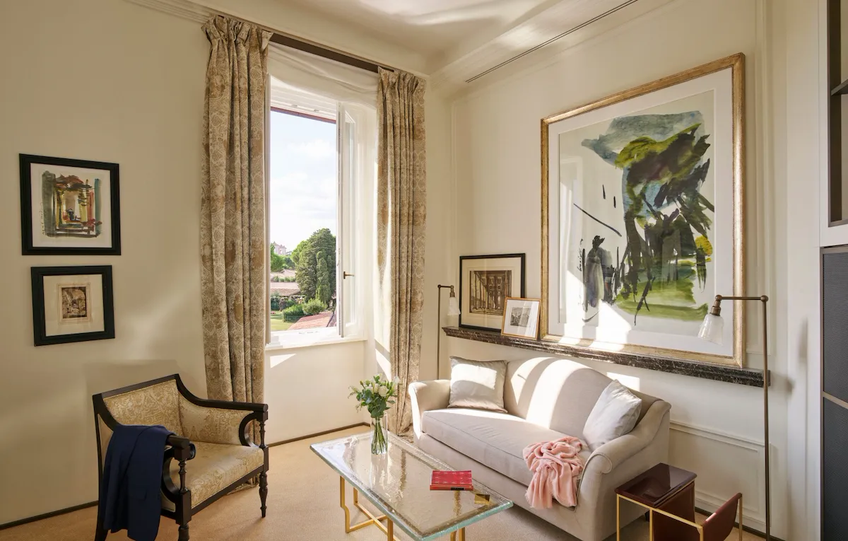 Living room with couch, armchair, paintings and coffee table at Classic Suite with view at Hotel Eden, Rome