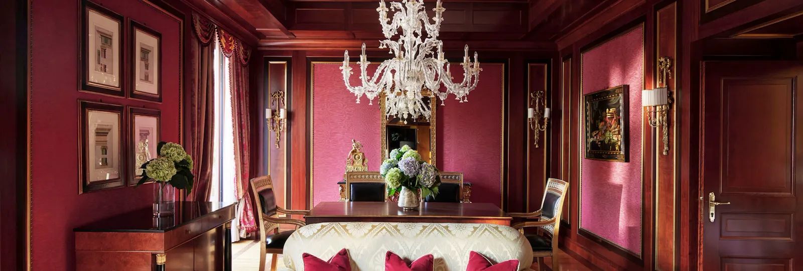 Royal Suite Living Room Overview revealing a predominantly red décor and a contrasting white sofa in the foreground