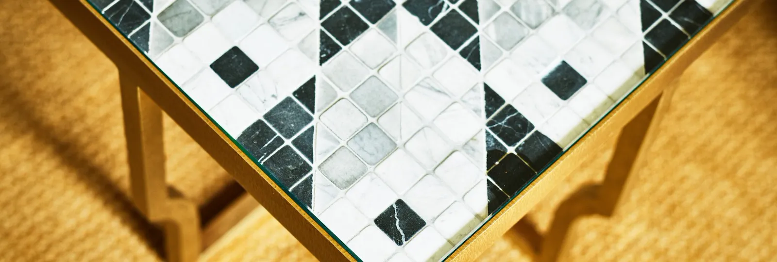 Coffee table with black and white tiles and golden base at Classic Suite at Hotel Eden, Rome