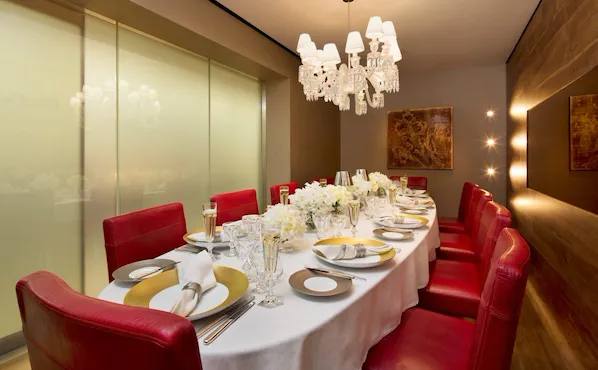 Chef's Table private dining area. Table set for 10 guests with white and gold setting and floral arrangements.