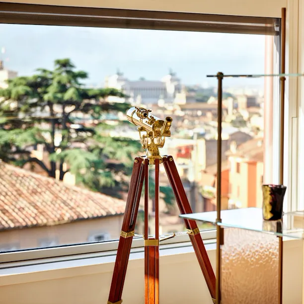 Telescope in front of open window in Bella Vista Penthouse suite at Hotel Eden, Rome