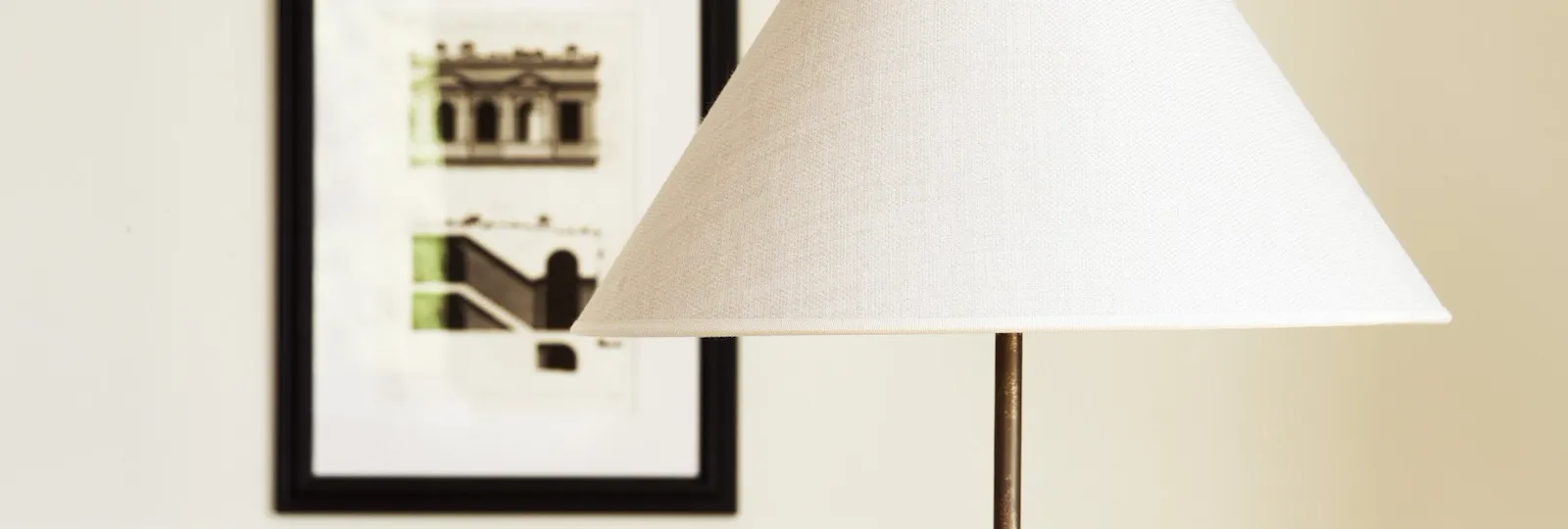 Lamp with white lampshade and paintings in the background at Dolce Vita Suite at Hotel Eden, Rome