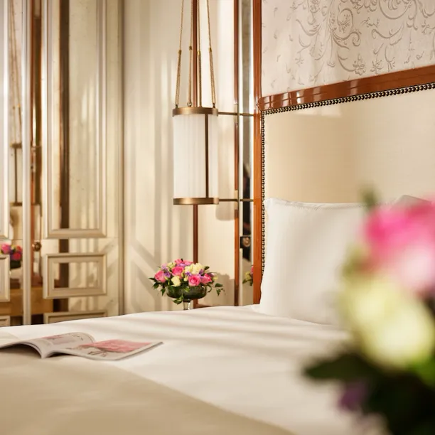 Close up on bedroom of prestige room, headboard with peacocks, night tables with flowers, at Hotel Eden, Rome