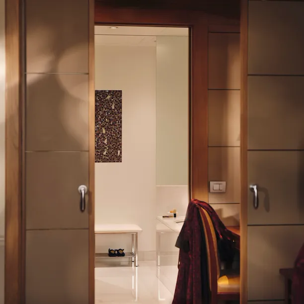 View of the bathroom from the Mosaic Room with a magazine in the foreground and a red robe in the background