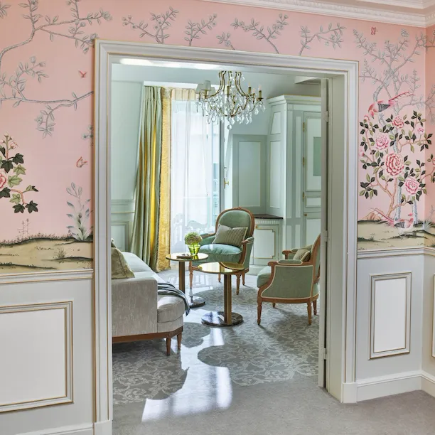 Distant shot of the living room, highlighting the pink wallpaper in the room, at Le Meurice, Paris.
