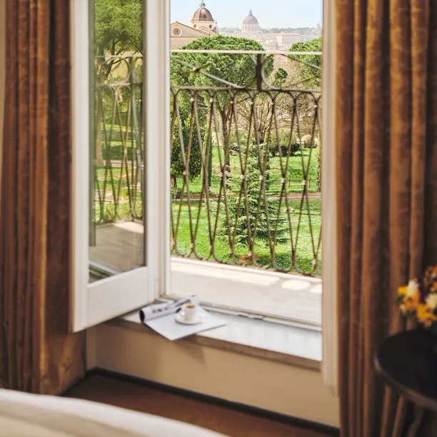 Cap of coffee and magazine on a balcony with view over Rome at Hotel Eden