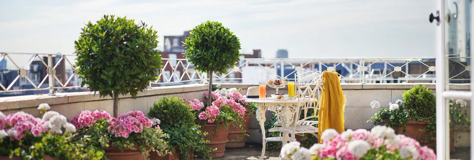 Oliver Messel suite sunny terrace with pink flower pots at The Dorchester, London