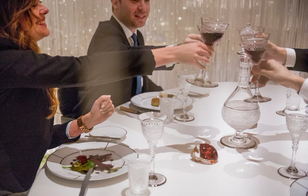 Alain Ducasse at The Dorchester Table Lumiere guests enjoying dinner and clinking glasses