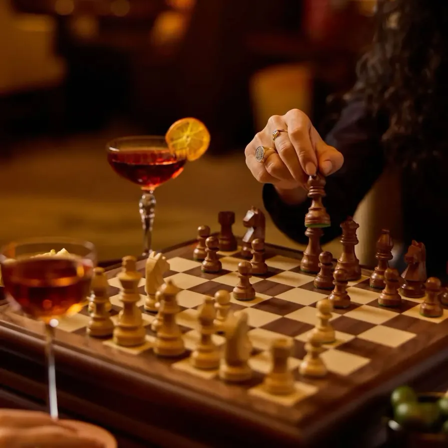 people playing Chess at Principe Bar with cocktails and olives on the table