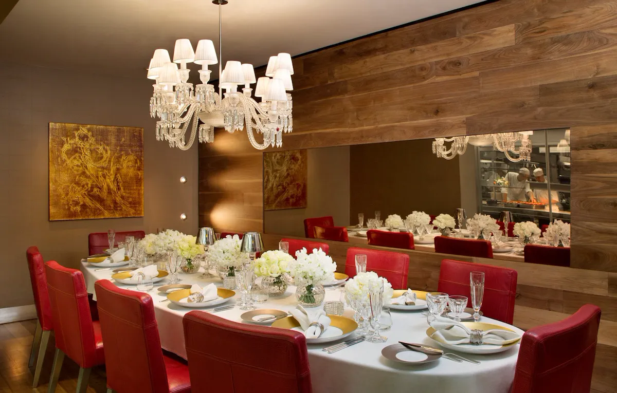 Chef's table set for 10 people with gold and white arrangments.