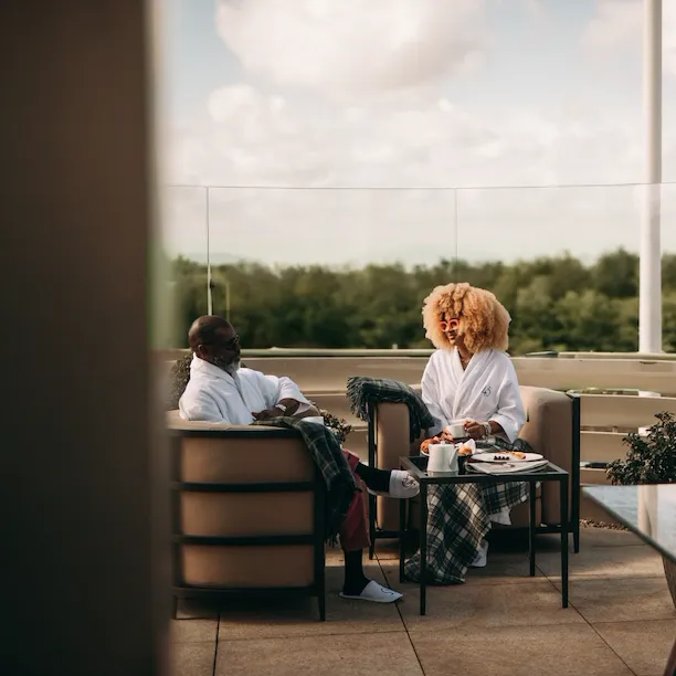 The terrace in the Penthouse suite at 45 Park Lane. Two people having breakfast on the terrace overlooking Hyde Park.