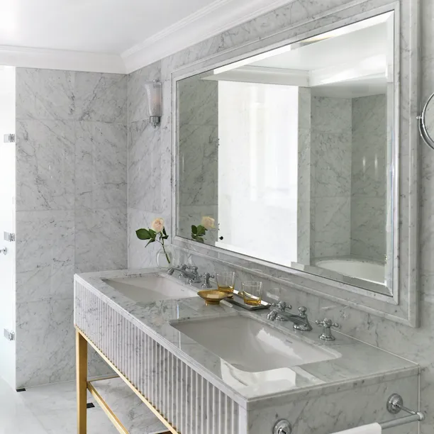 Deluxe Room at The Dorchester in Morning light bathroom mirror and sink with marble details
