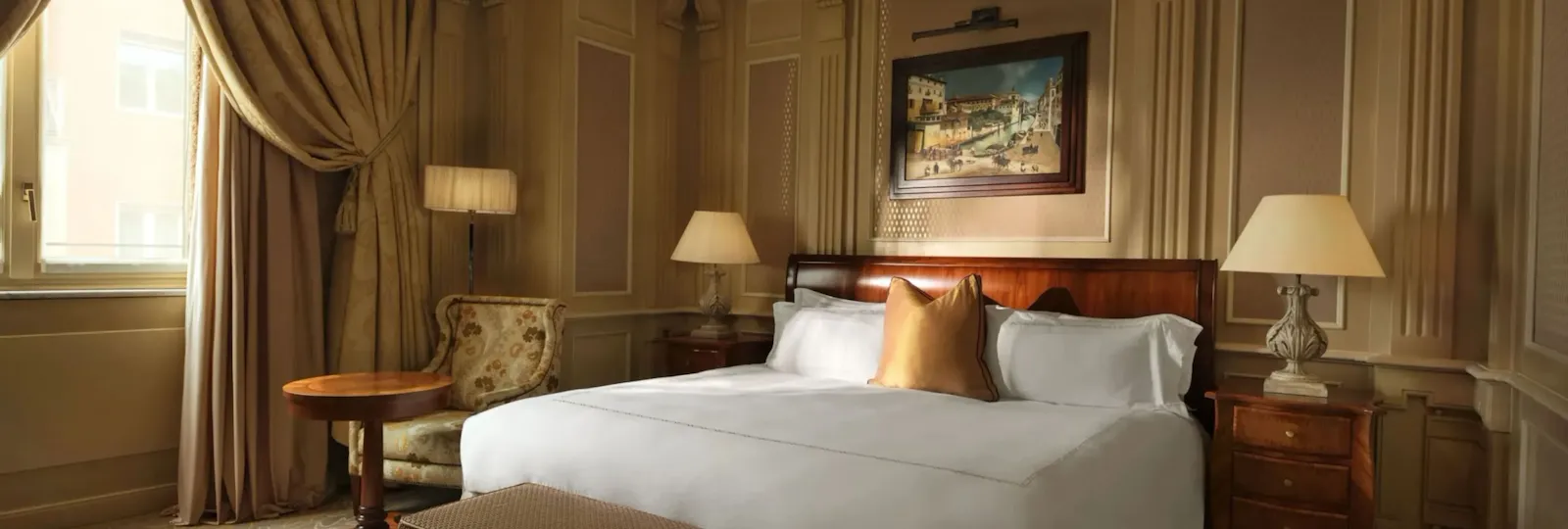 Classic room with soft cream and gold colors, wood details and bedside lamps