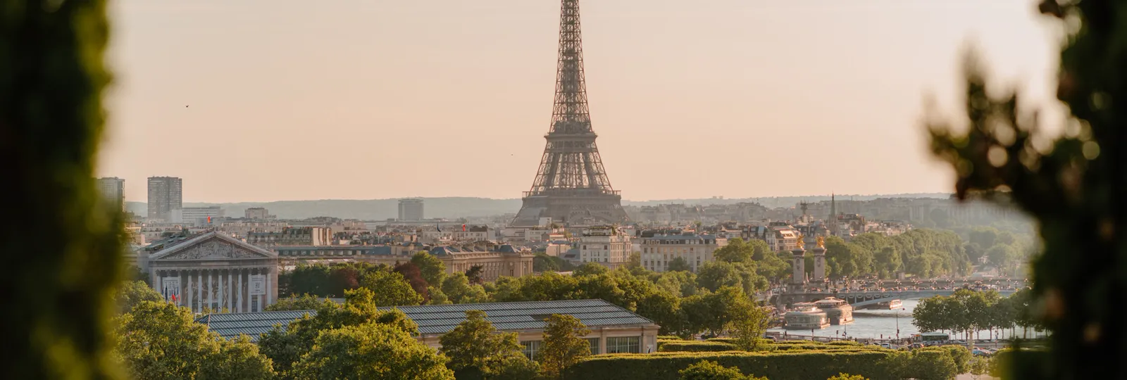 Distant andscape view of the Eiffel tower with trees surrounding the picture, at the Eiffel tower, Paris.