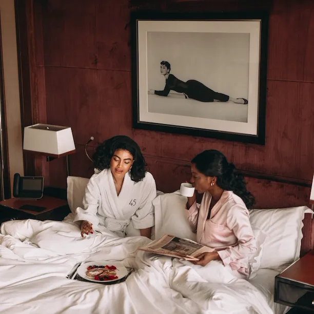 Two people sat in The Penthouse suite bedroom at 45 Park Lane