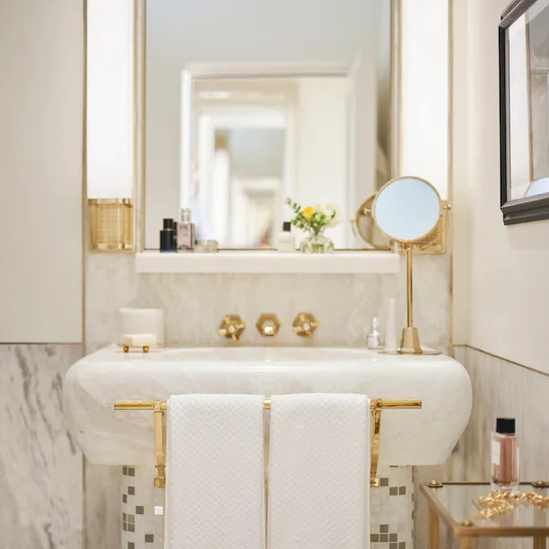 Bathroom of Classic Suite with white marble sink, towels and mirror at Hotel Eden, Rome