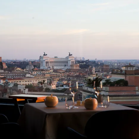 Tavolo per due davanti la vetrata del ristorante La Terrazza con vista sul Vittoriano  a Roma