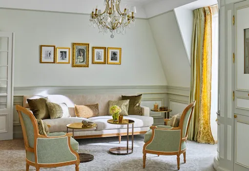Living room of a deluxe junior suite with green and yellow undertones, at Le Meurice, Paris.