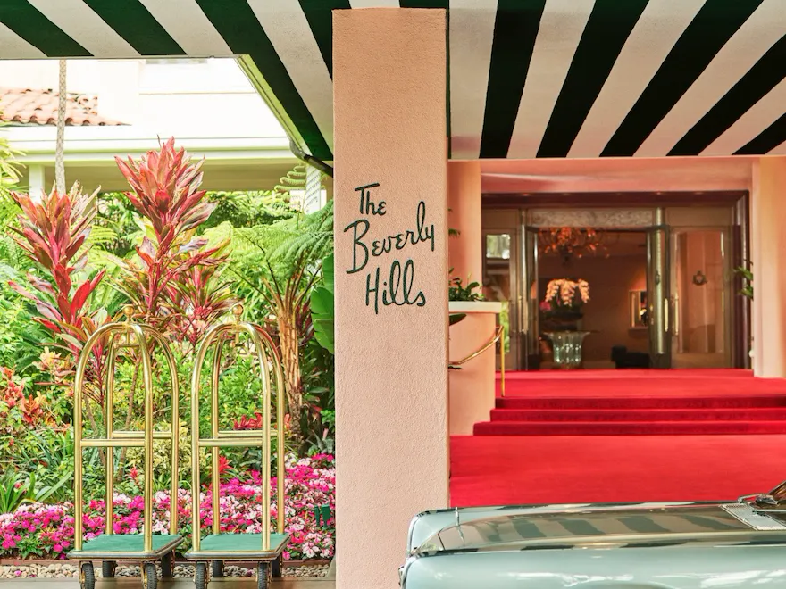 The Beverly Hills Hotel red carpet entrance with car and bellman carts.