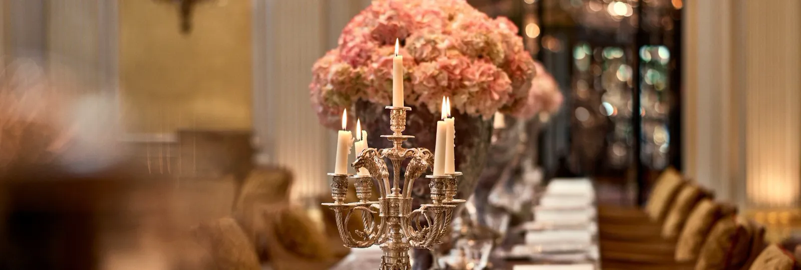 Jean Imbert au Plaza Athénée's central marble table, drawned up with pink flowers and candleholders. At Hotel Plaza Athénée, Paris