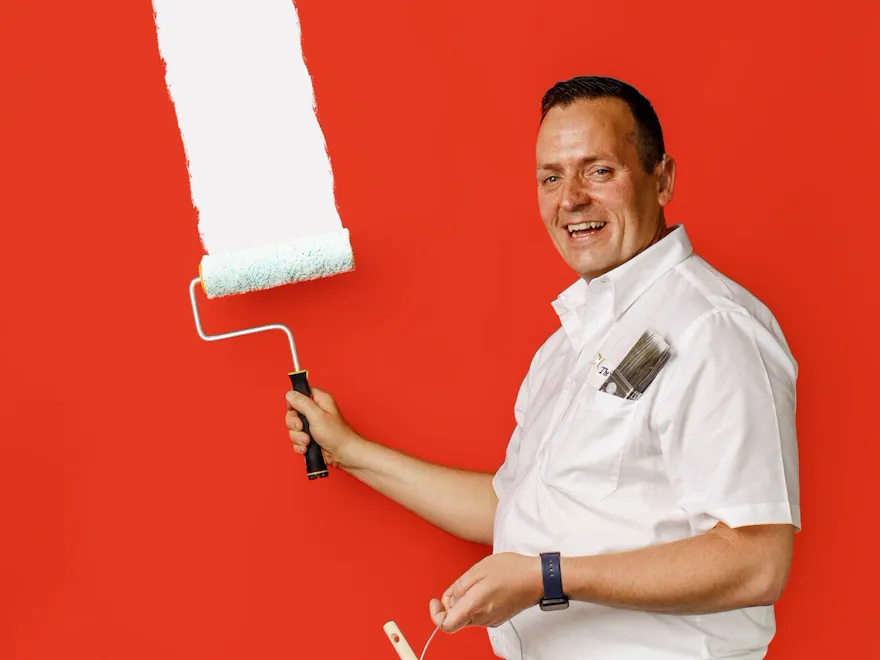 Martin Seymour painting with white paint on a red background